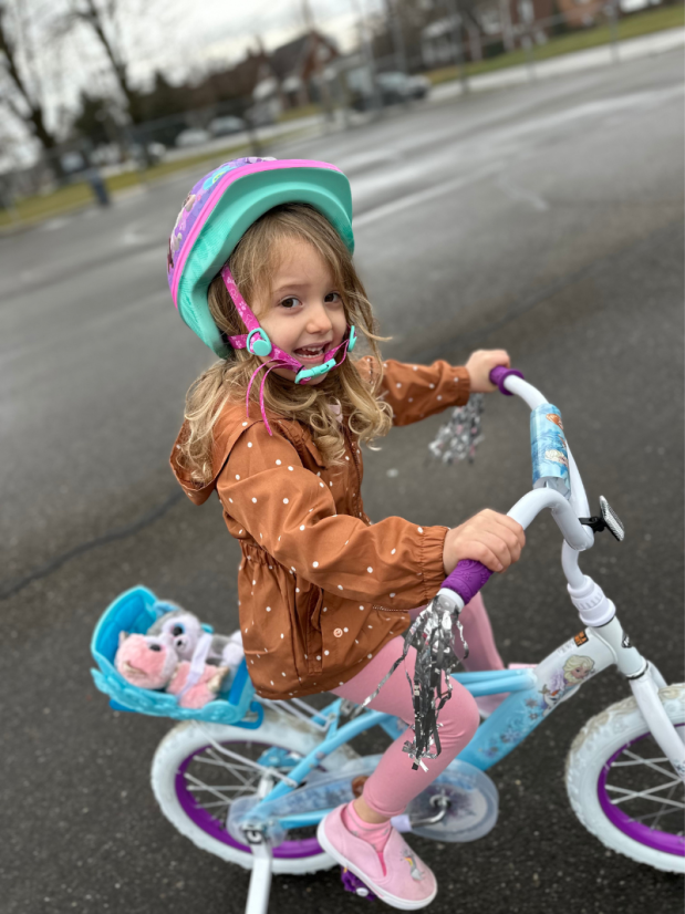 Girl riding a bike with training wheels
