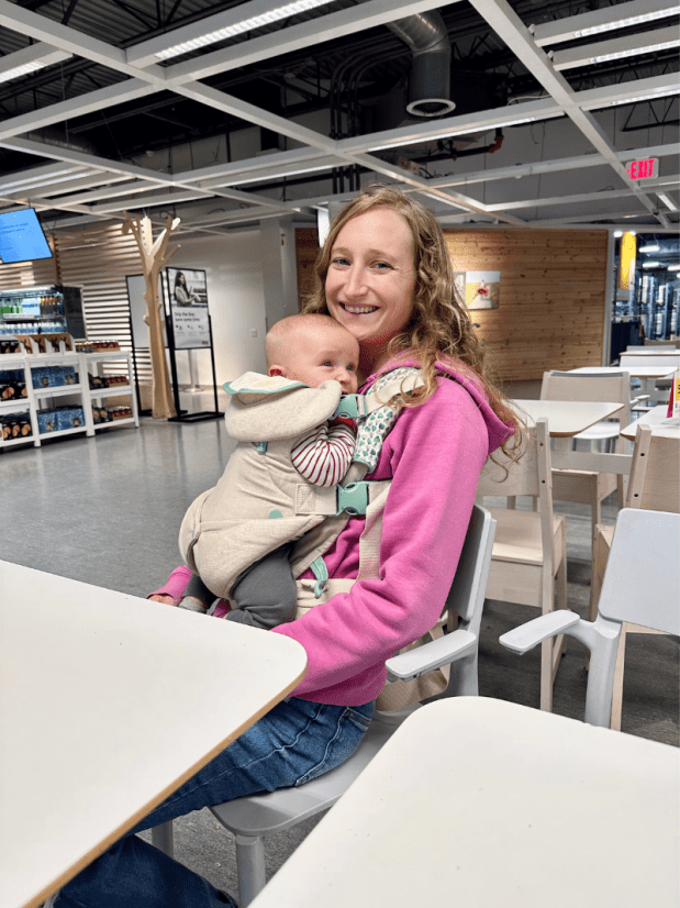 Mom sitting with baby in carrier at IKEA