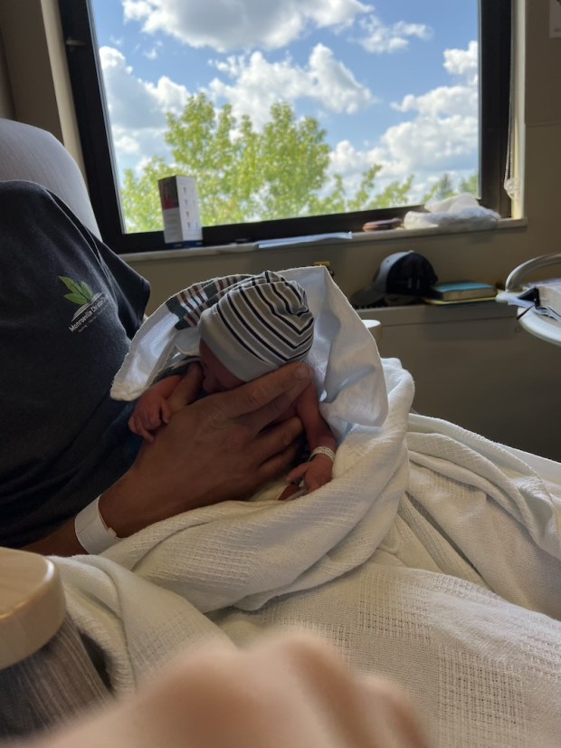 Guy holding three pound baby in hospital