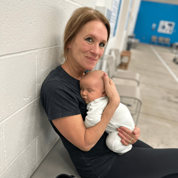 Baby boy sleeping on grandma's chest at indoor pool