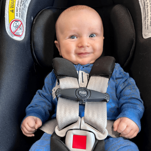Baby boy smiling in carseat