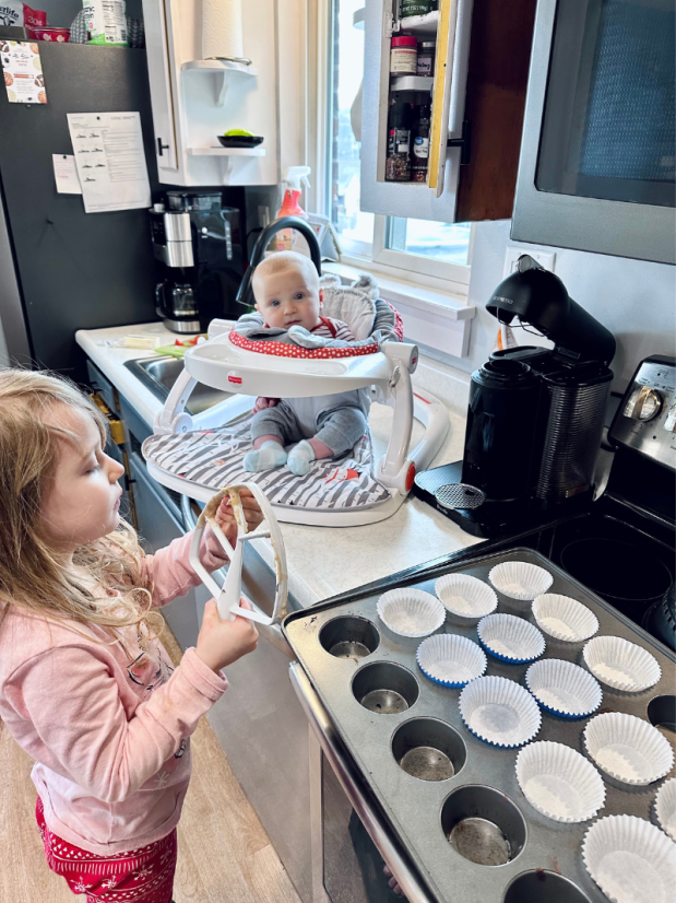 Young girl baking with baby watching
