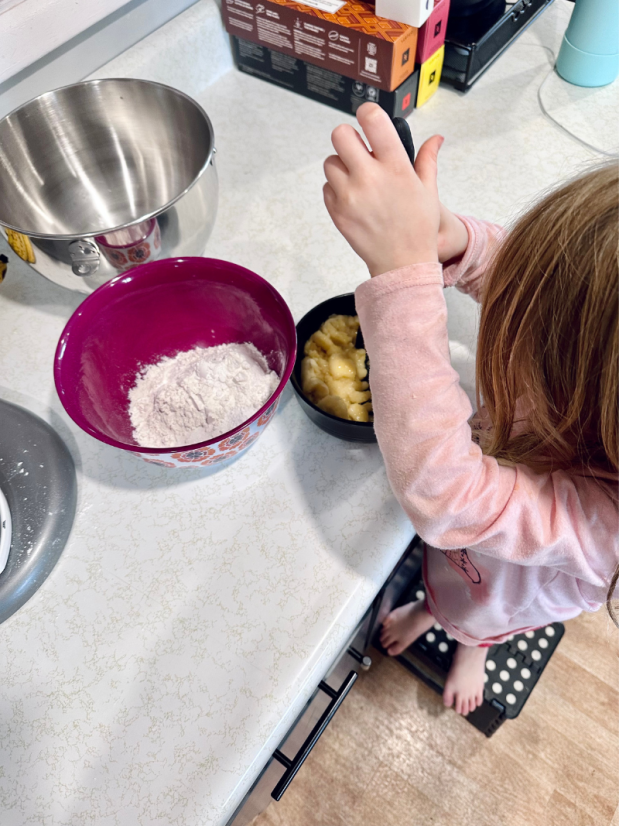 Young girl mashing bananas for banana muffins