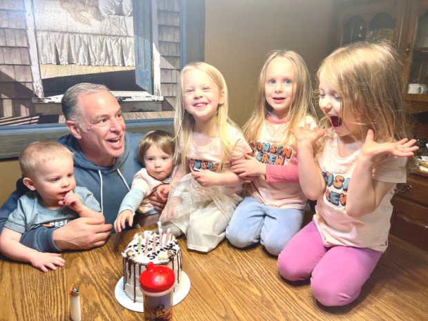 Kids surrounding cake with grandpa