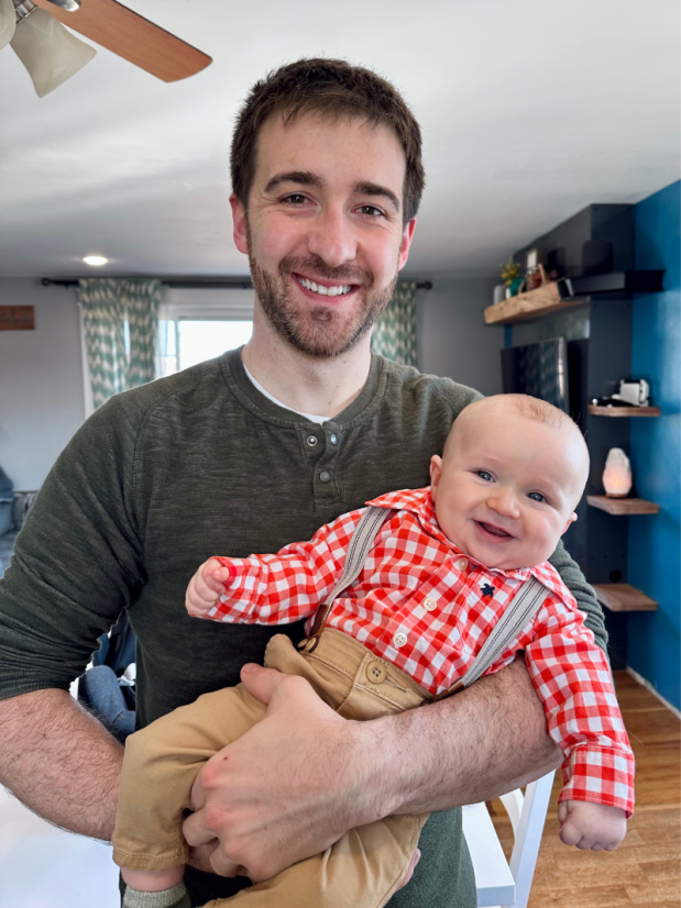 Dad holding baby boy with suspenders