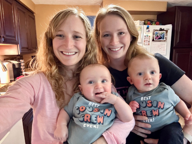 Sisters holding baby boys with Cousin Crew onesies