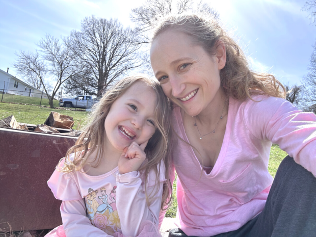Mom and daughter sitting in grass wearing pink