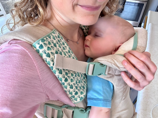 Baby boy sleeping in carrier on mom