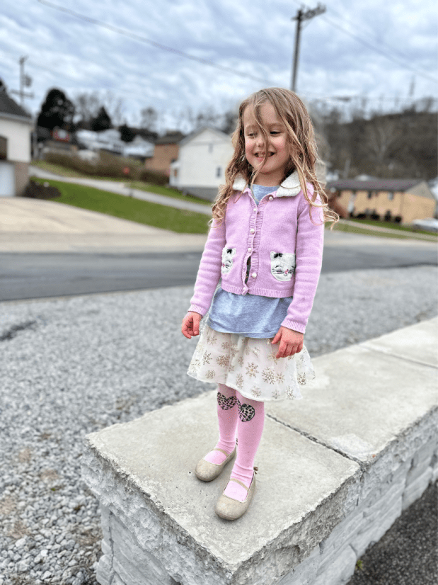 Girl standing on bollard at park