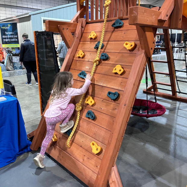 Girl climbing rock wall on swing set