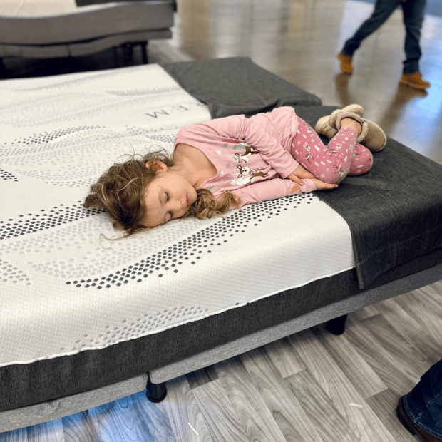 Young girl sleeping on a bed display