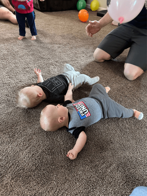 Baby boys laying on carpet together