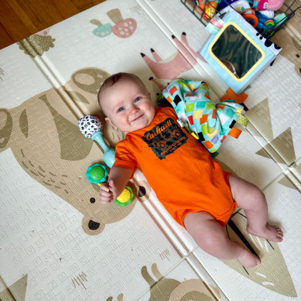 Baby boy laying on play mat