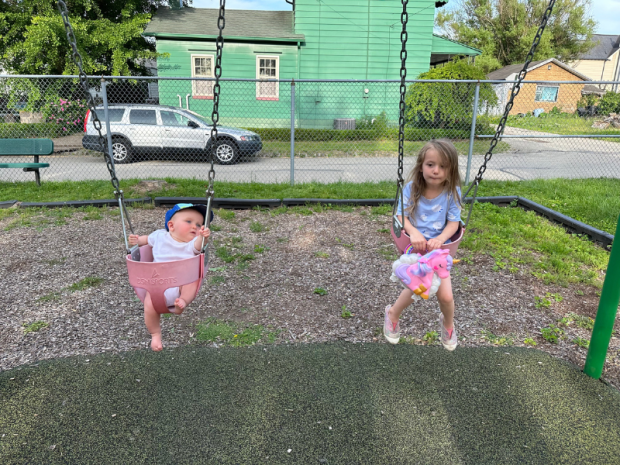 Brother and sister on swings together