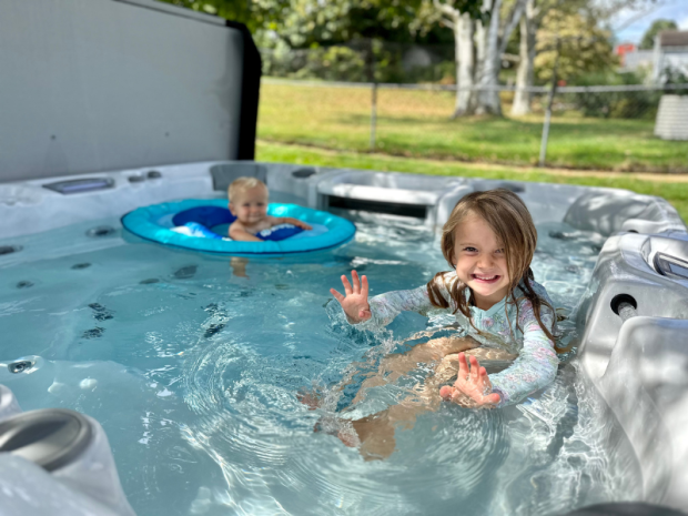 Girl and baby boy swimming in hot tub