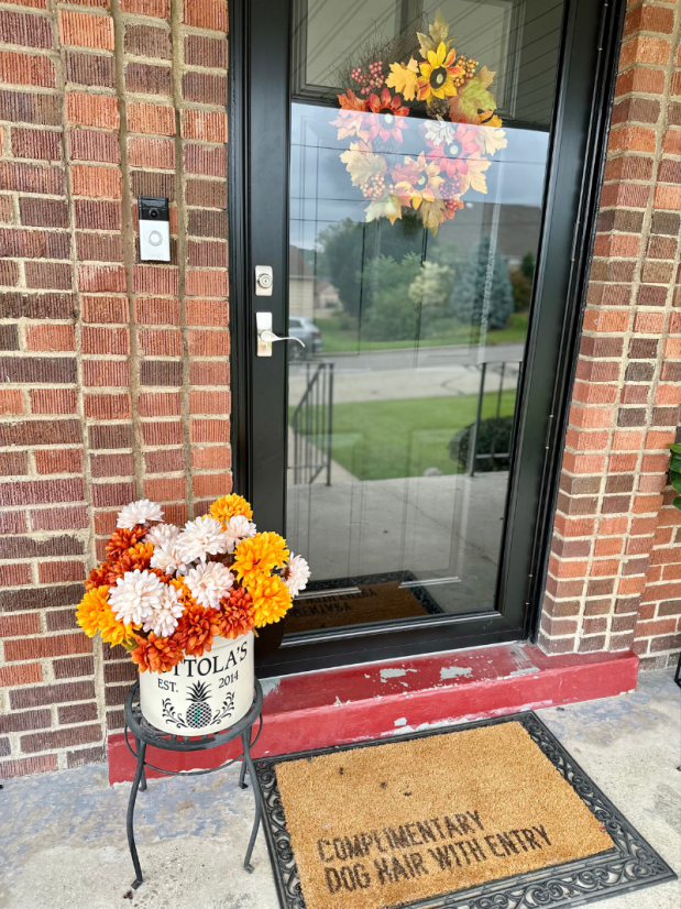 Front porch decorated for fall with mums and wreath
