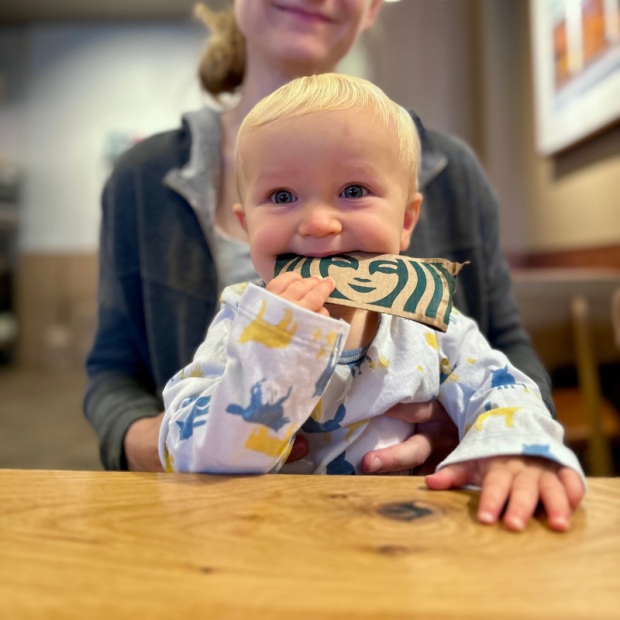 Baby boy chewing on Starbucks Coffee sleeve