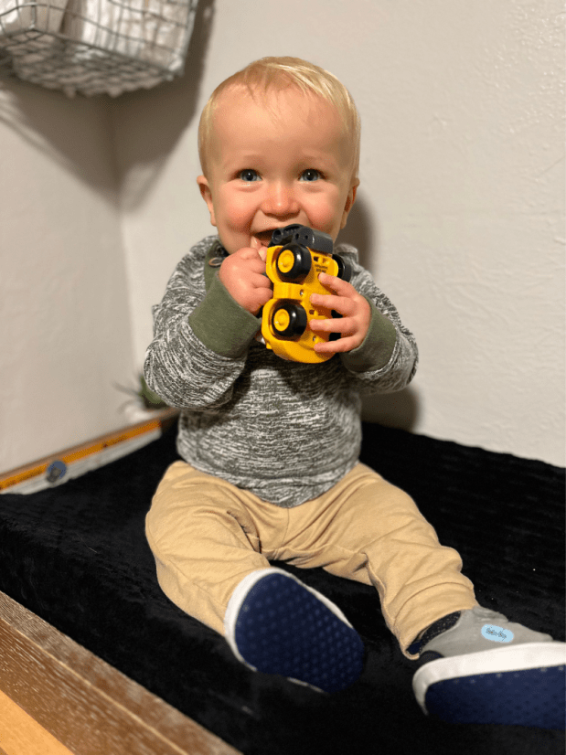 Baby boy playing with a toy tractor