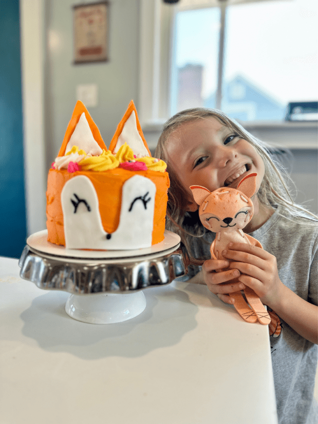 Girl with homemade fox birthday cake
