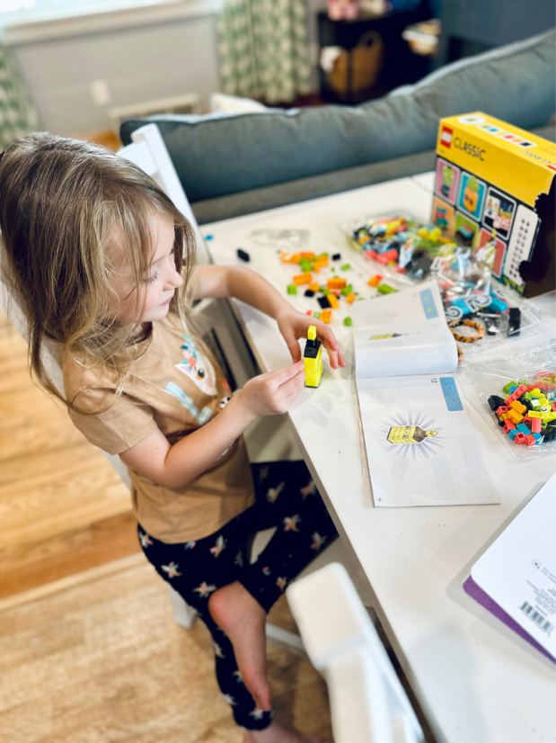 Girl putting together a Lego set