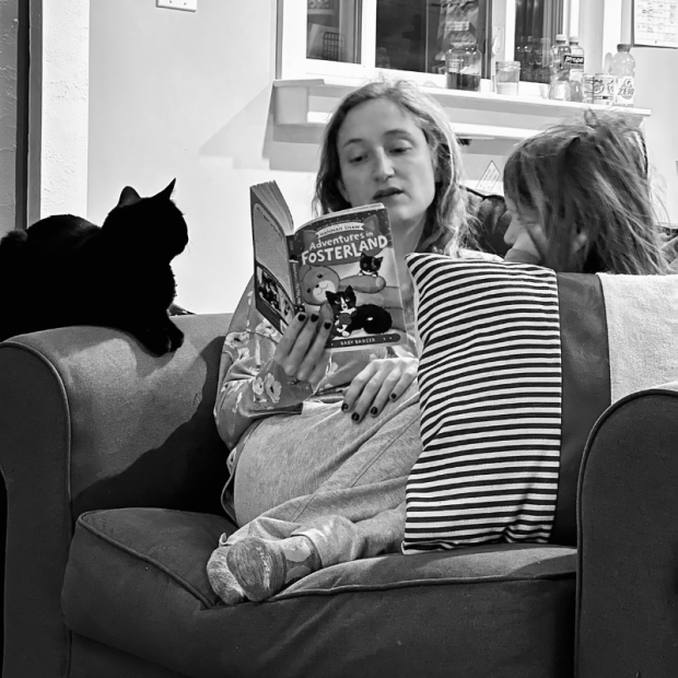 Mom reading to daughter and cat