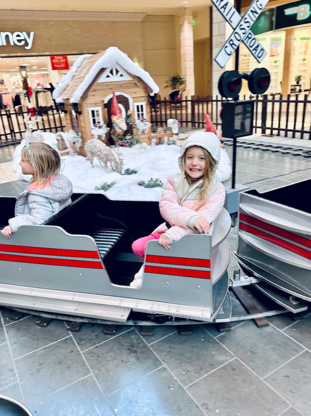 Girl riding Christmas train at shopping mall