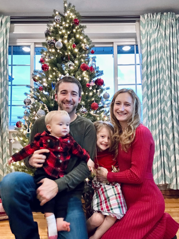 Family photo by Christmas tree with mom, dad, girl, and baby boy