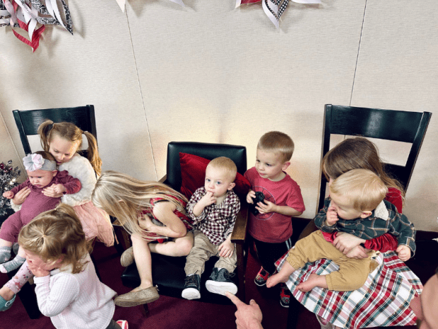 Eight grandkids sitting on chairs for Christmas pictures