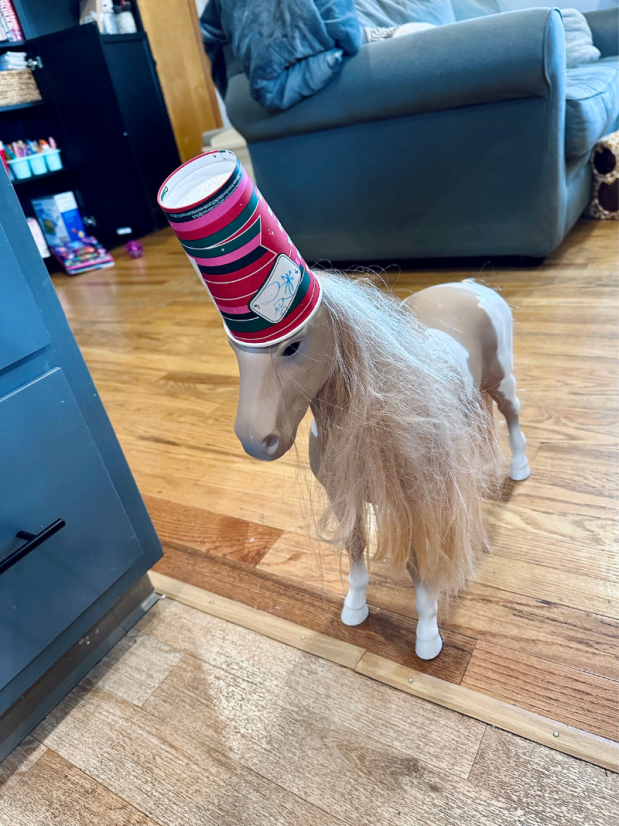 Doll horse with Starbucks cup on its head