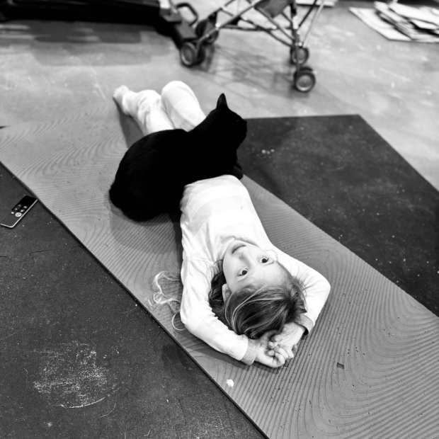 Girl with black cat lying on her stomach