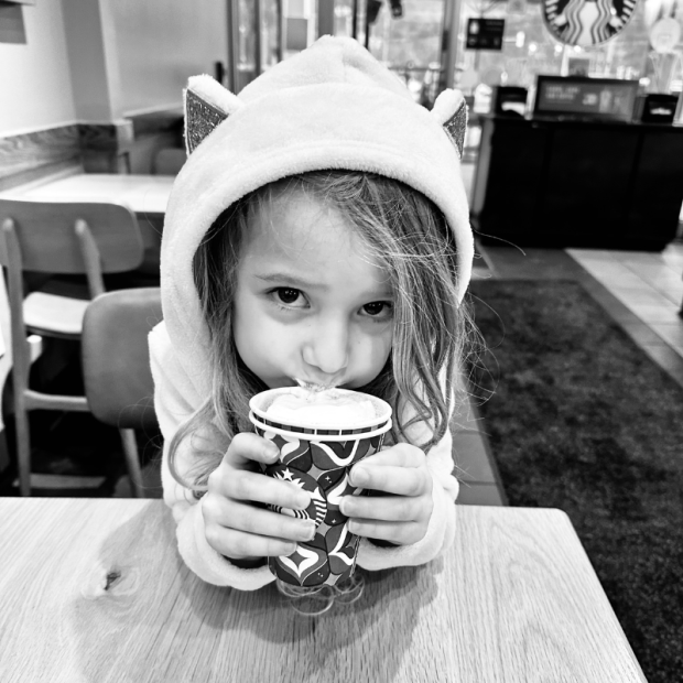 Girl drinking hot cocoa in Starbucks