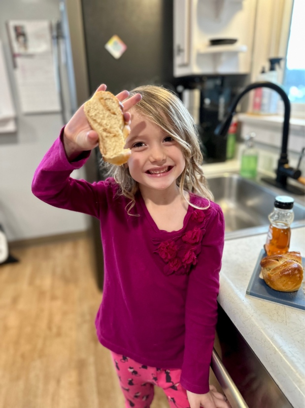 Girl holding slice of challah bread