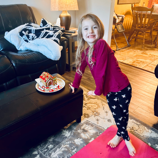 Girl standing by gingerbread house
