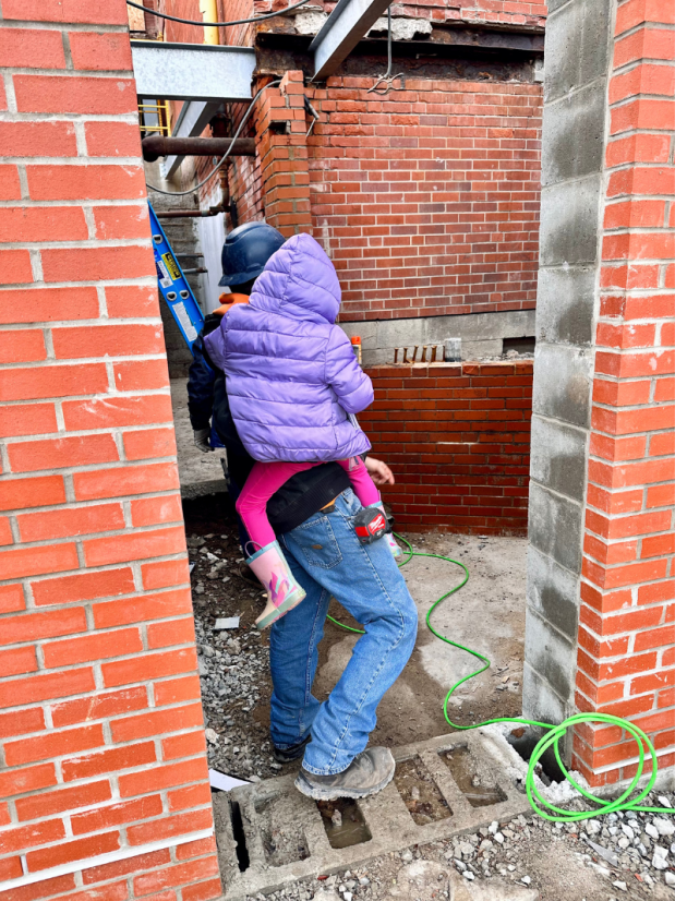 Dad holding daughter on job site