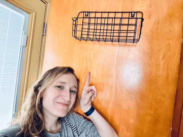 Girl pointing at basket she hung by herself