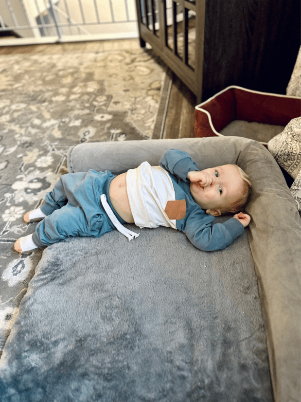 Baby boy laying on dog bed