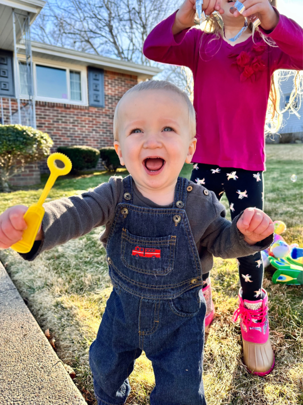 Baby boy holding bubble want and smiling