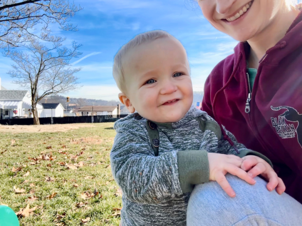 Baby boy standing in yard smiling