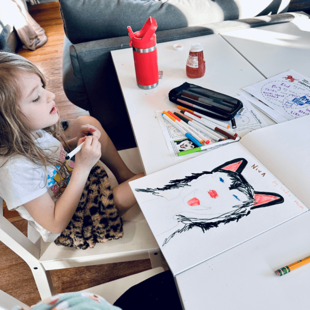 Girl drawing a picture of a Siberian husky