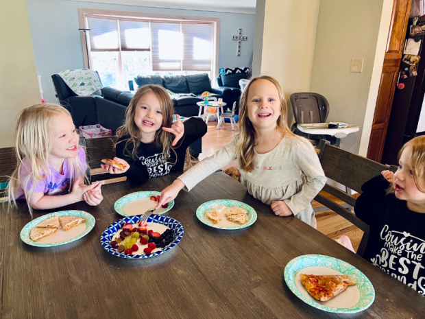 Girls sitting together eating quesadillas and fruit