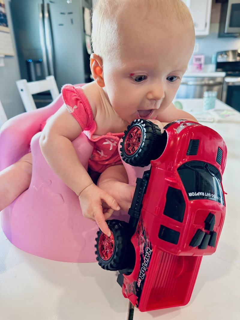 Baby playing with red Ford Raptor truck