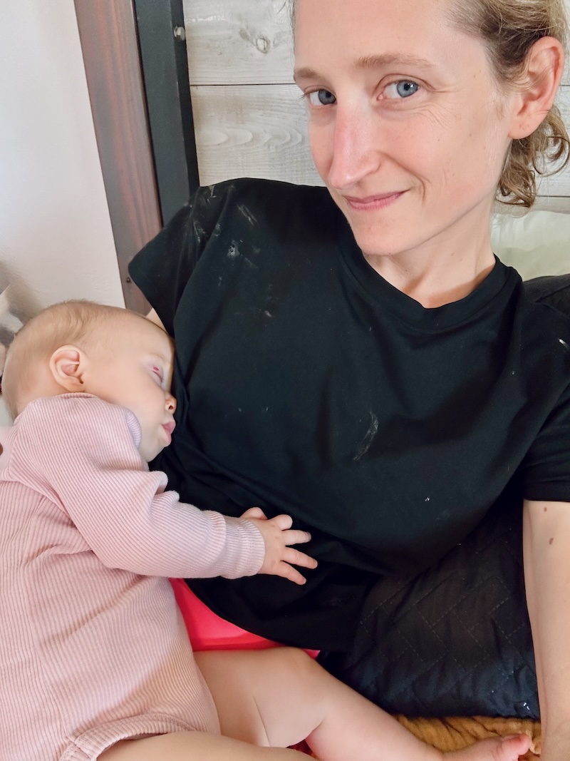 Mom snuggling sleeping baby girl.