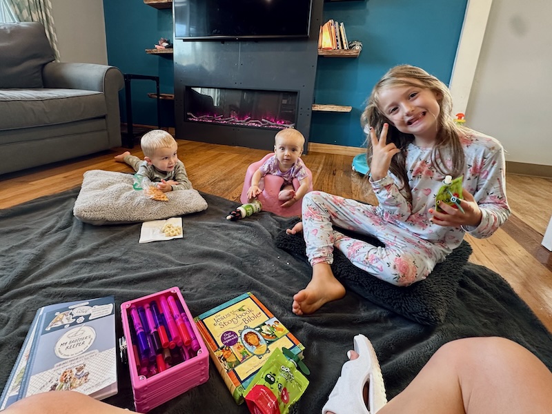 Kids sitting on floor with snacks and Bible