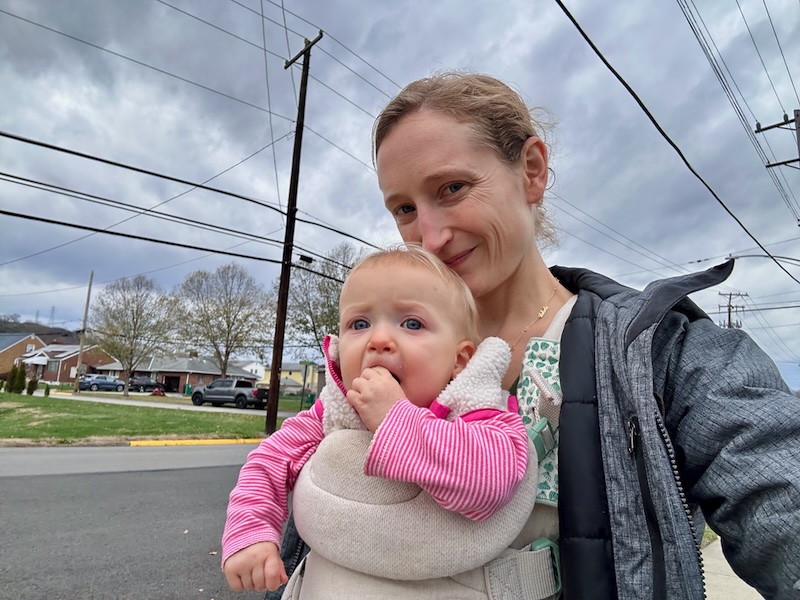 Mom with baby in baby carrier outside