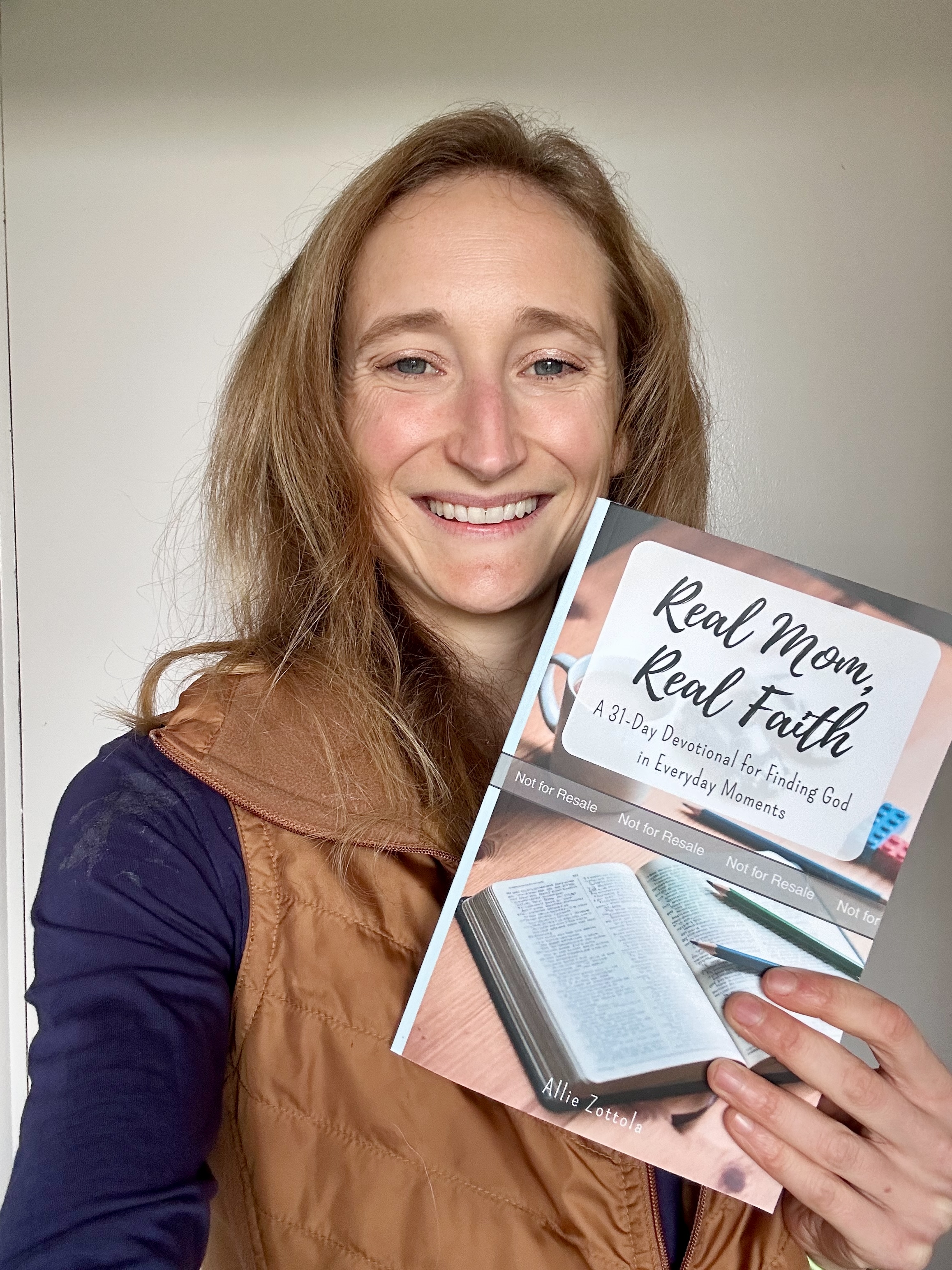 Allie Zottola holding Real Mom, Real Faith book