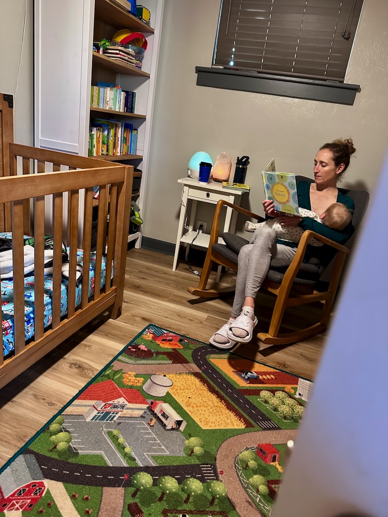 Mom breastfeeding and reading to baby