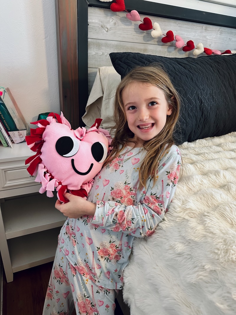 Girl holding Valentine's Day pillow