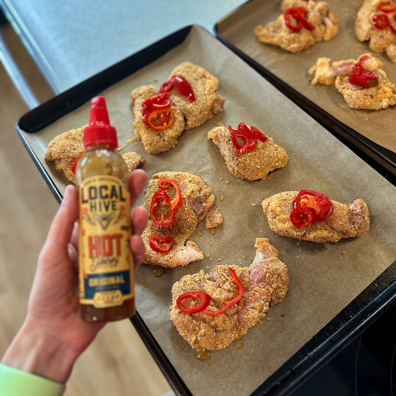 Spicy chicken on pan with hit honey and peppers