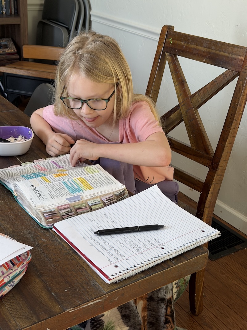 Girl reading her Bible at table