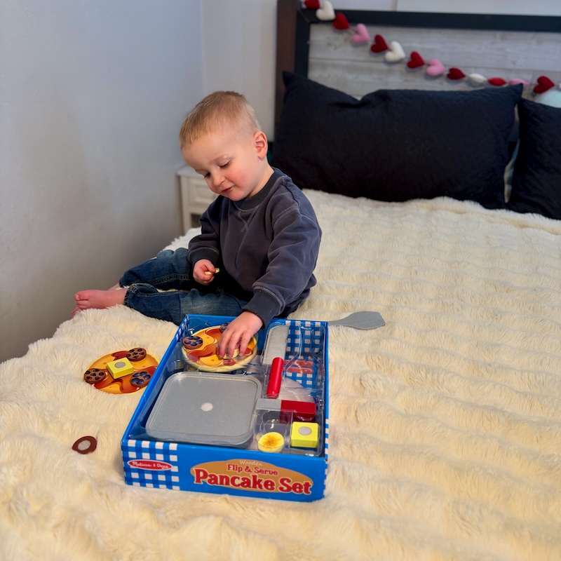 Toddler boy playing with Melissa and Doug pancake toy